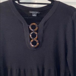 Sweater with tortoise shell ring embellishments.